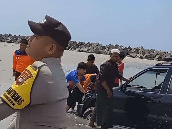 Polisi mengevakuasi mobil dan motor yang terjebak di pasir pantai